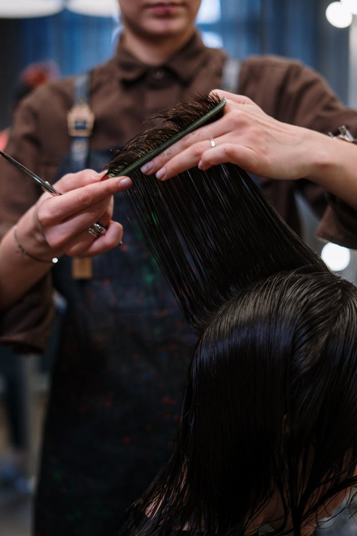 services-03 Close-up of a hairstylist cutting wet hair in a professional salon.