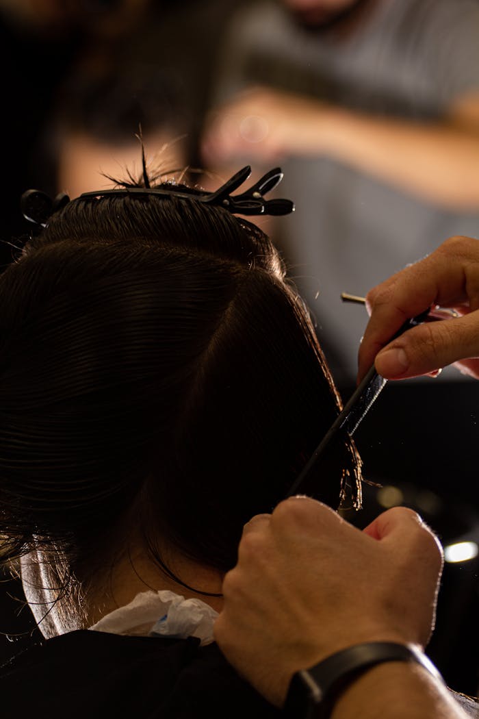 services-02 A hairdresser carefully cuts hair, focusing on precision and style.